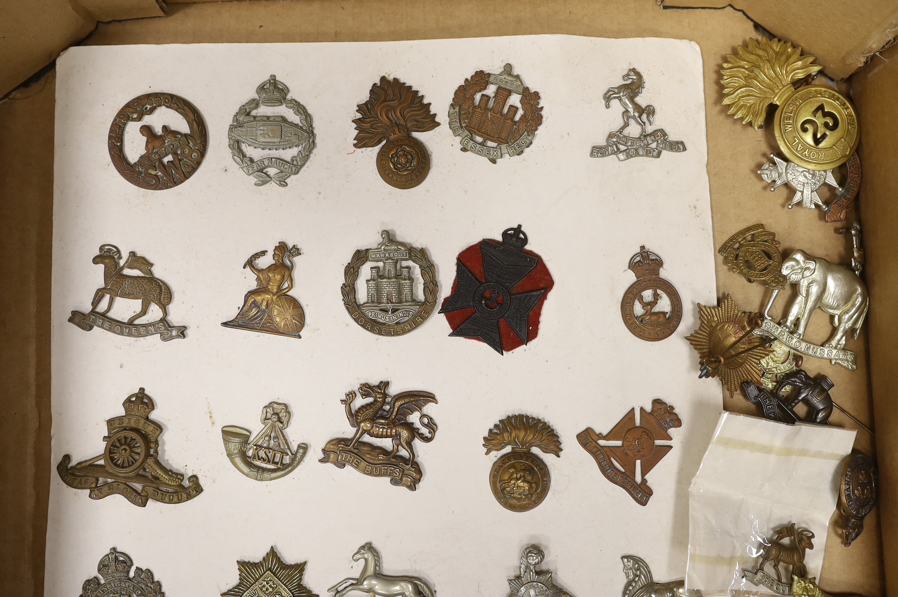 A collection of military cap badges, including Royal Sussex Reg, Royal Warwickshire, King’s Own Hussars, Leicestershire, Royal Welsh Fusiliers, etc. (65)
